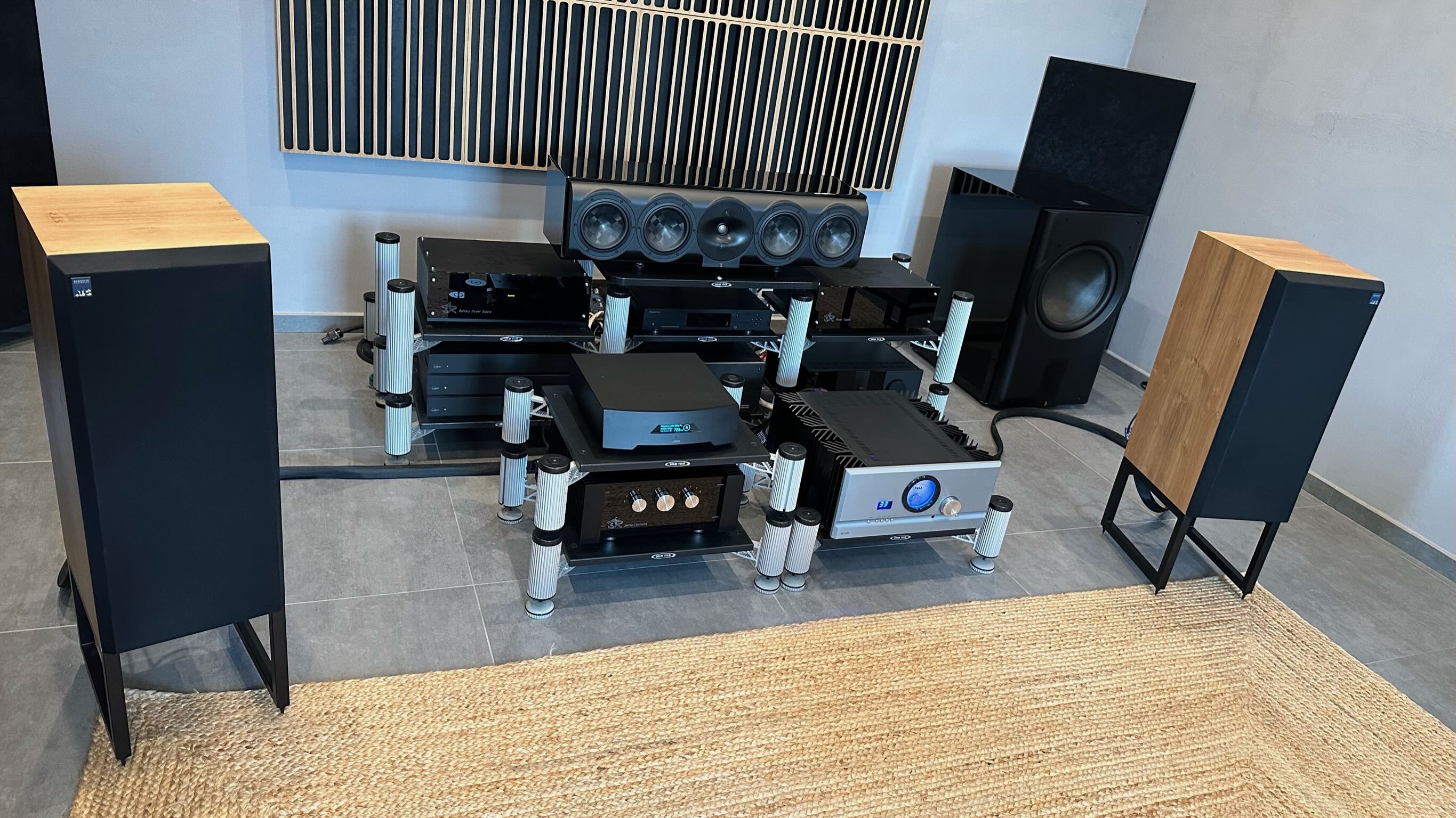 Audiophile en position d'écoute face à enceintes ATC SCM50 dans salon acoustiquement traité